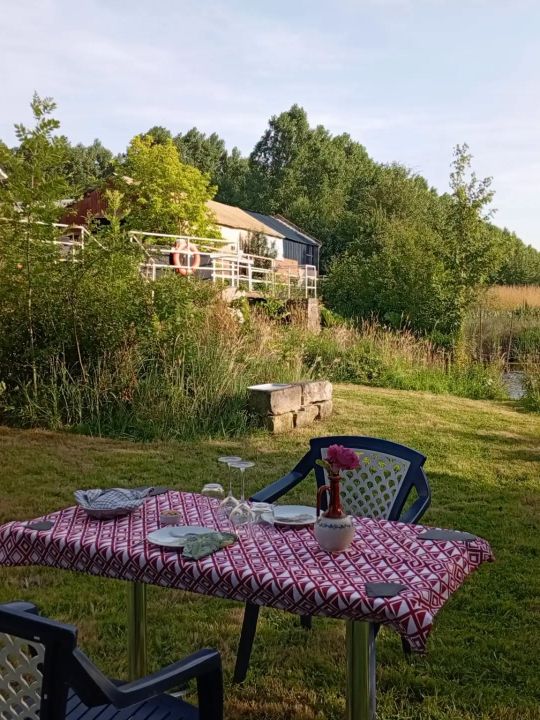 Les Berges du Moulin — La terrasse au bord de l'eau et la presqu'île offrent un cadre privilégié pour profiter de la rivière, se retrouver dehors ou simplement prendre le temps. Les Berges du Moulin — La terrasse au bord de l'eau et la presqu'île offrent un cadre privilégié pour profiter de la rivière, se retrouver dehors ou simplement prendre le temps.